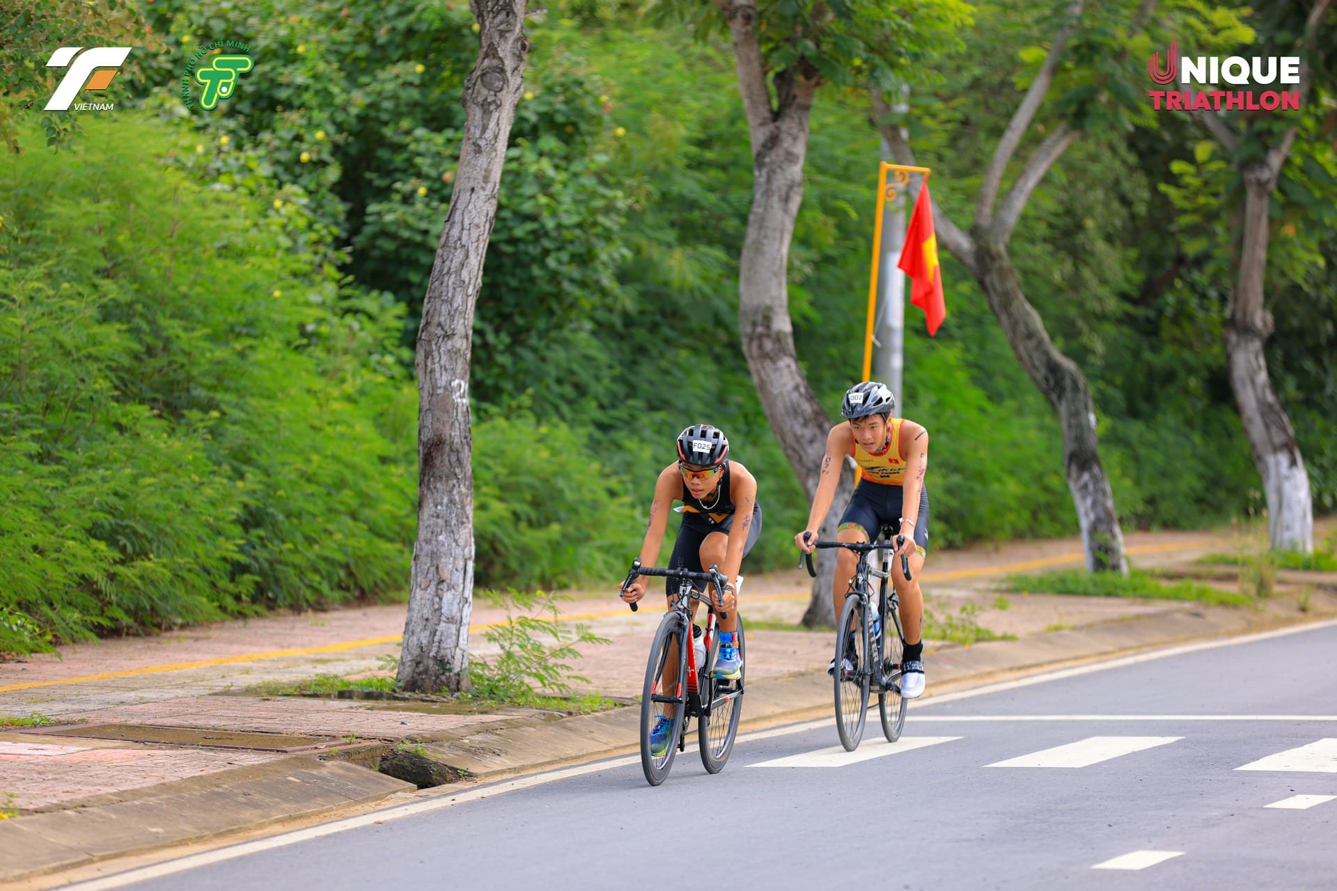 Hai học viên TriKids đạp xe trên đường tại sự kiện triathlon